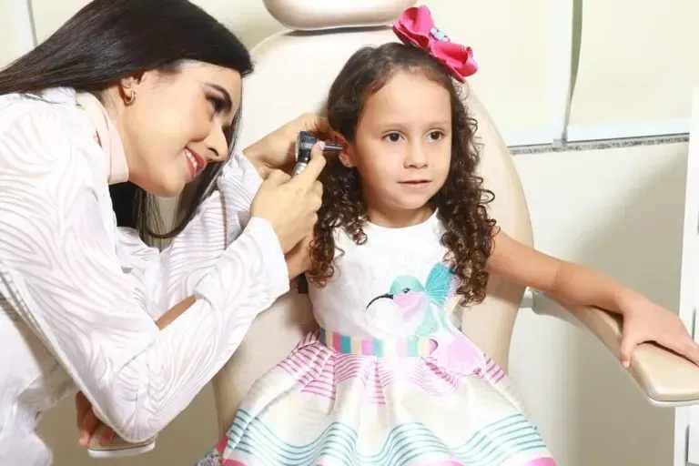 Dra. Liane examinando o ouvido de uma criança na Clínica CEOP